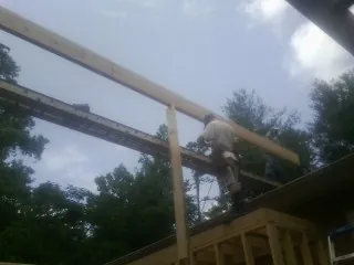 Carpenter setting a ridge beam over a new addition frame — Ice Dam Removal by Roofing Brothers in La Rose