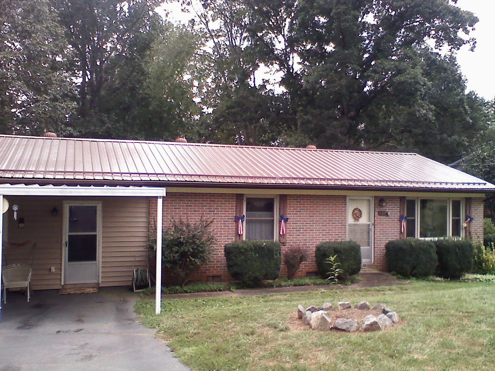 Bronze metal roof and carport on a brick ranch home — Roof Repair work by our crew in La Rose